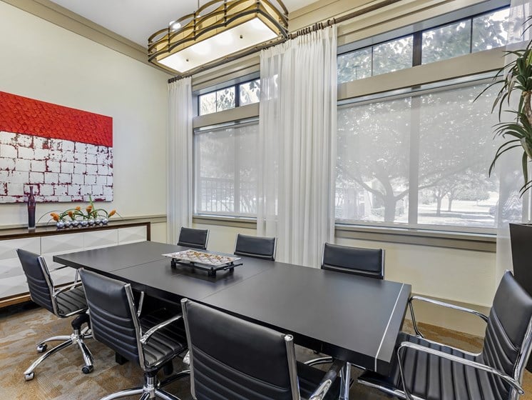 a conference room with a large table and chairs and windows